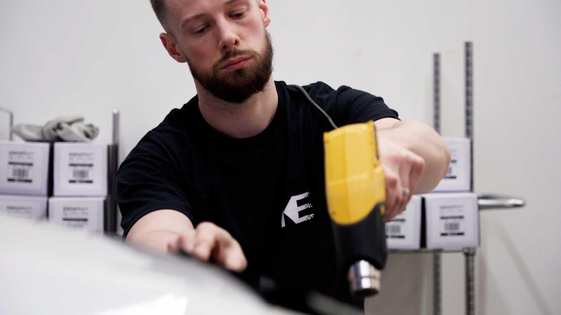 Kepler installer shrinking automotive window film with a heat gun